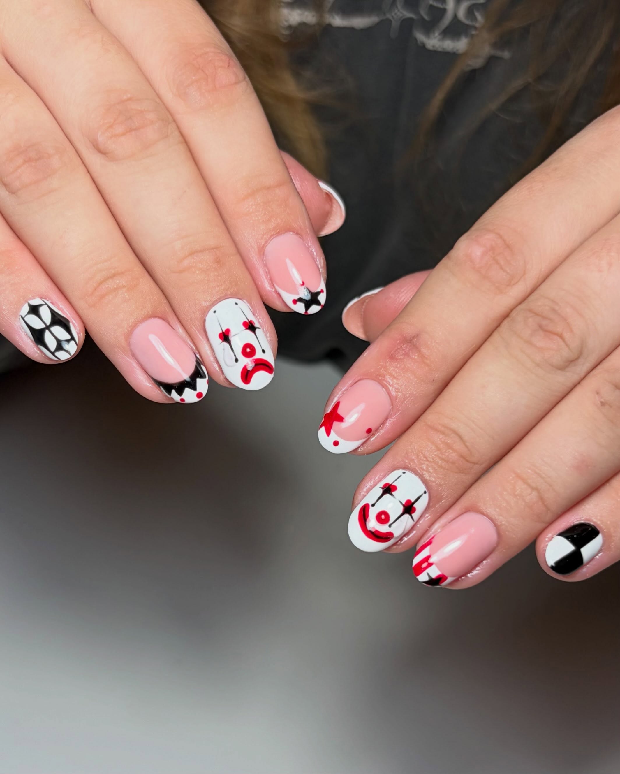 Clown-themed Halloween nail art with 3D tears on almond nails