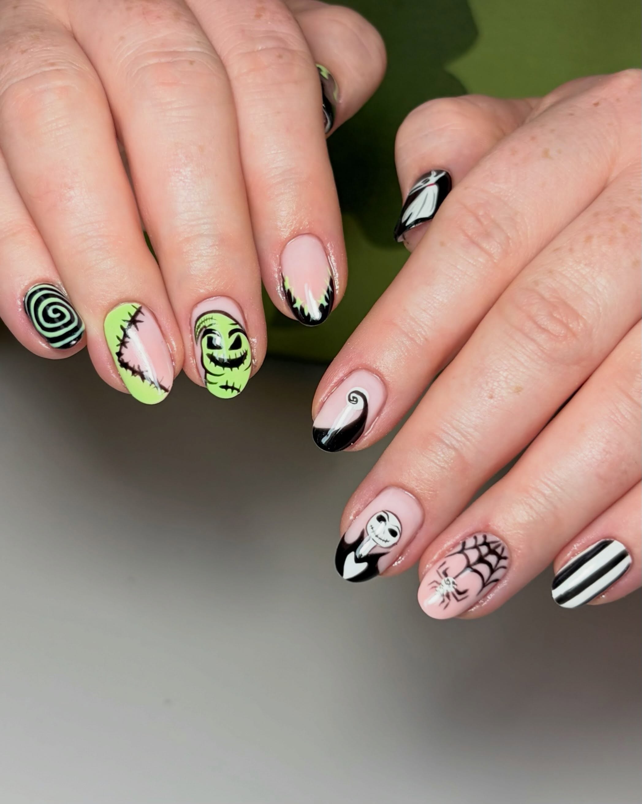 Green and black Halloween character nails with spiders and stripes