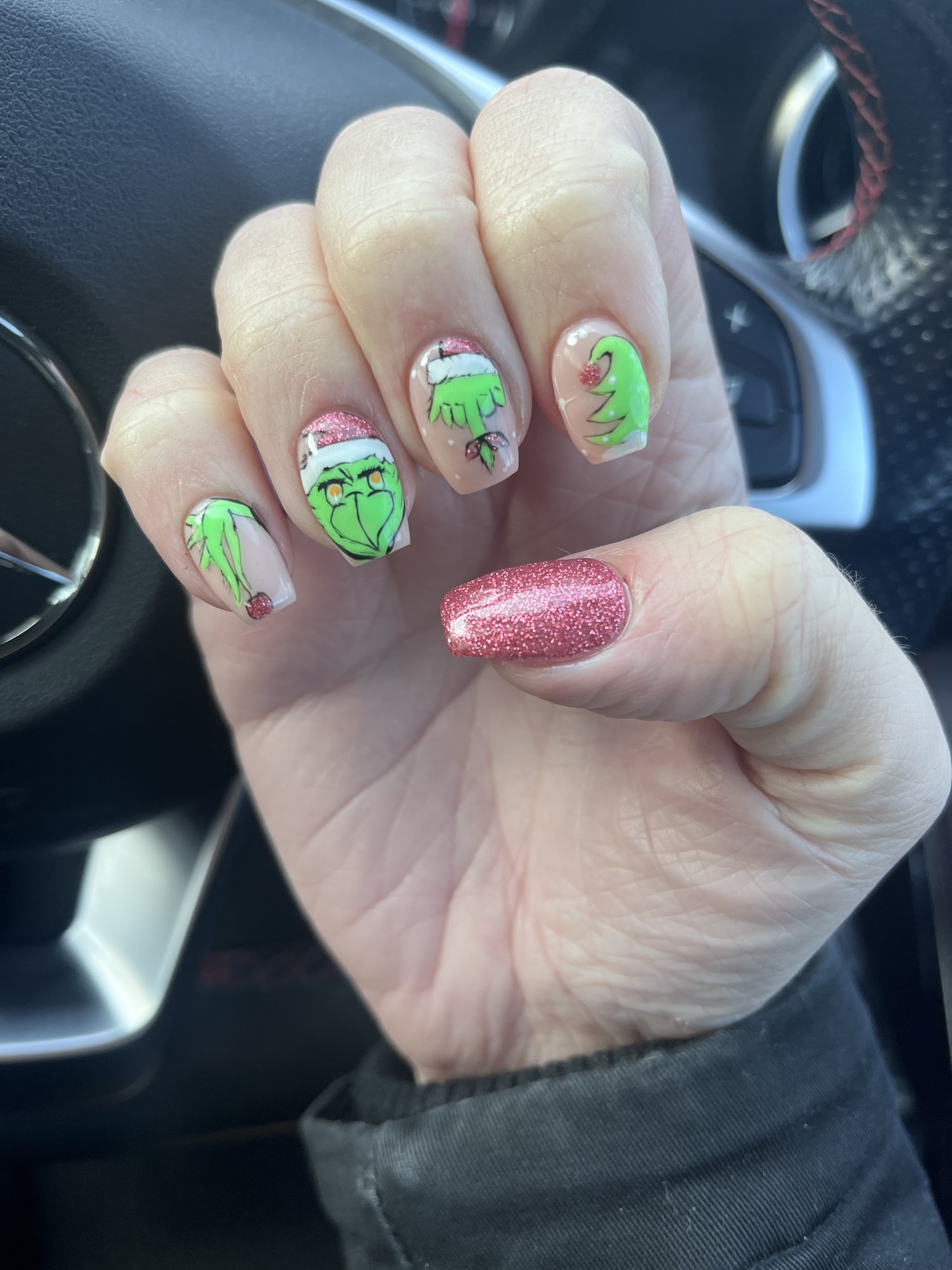 Grinch character nail art with a pink glitter accent
