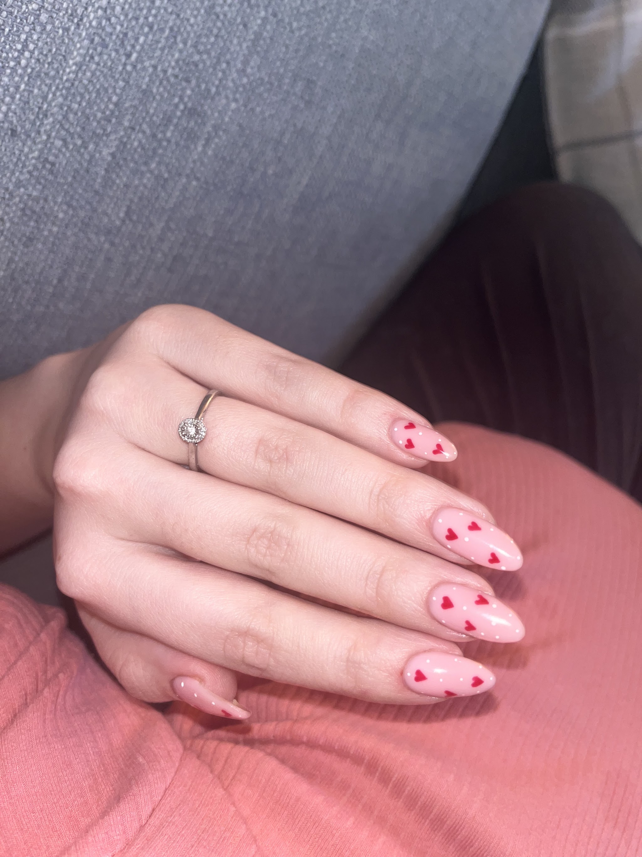 Pale pink almond nails with tiny red hearts