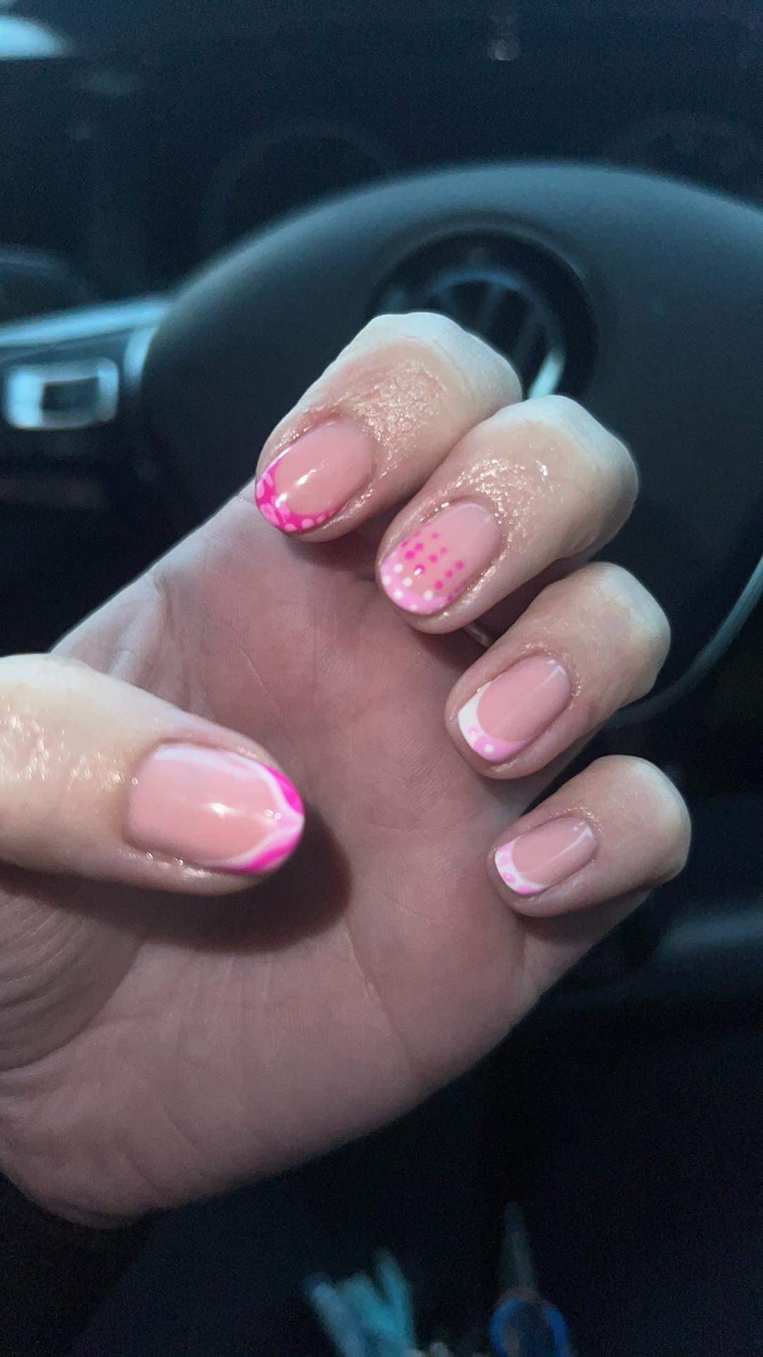 Nude nails with pink french tips and a floral accent