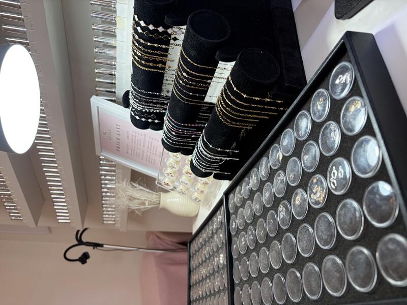 The welded jewellery station at The Beauty Room: trays of charms and chains on black velvet rolls